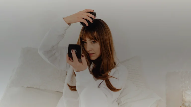 Une femme aux cheveux longs devant un miroir de poche