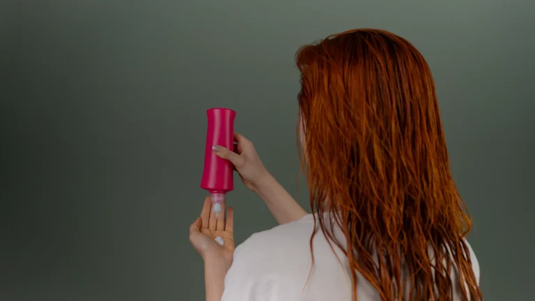 Une femme applique un masque sur ses cheveux mouillés