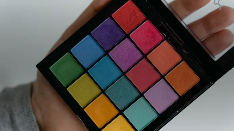 Une palette de fards à paupières colorés dans une main