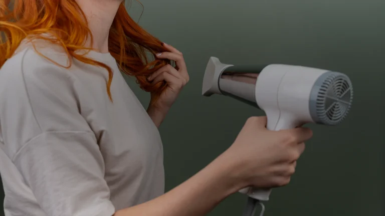 Femme séchant ses cheveux avec un sèche-cheveux