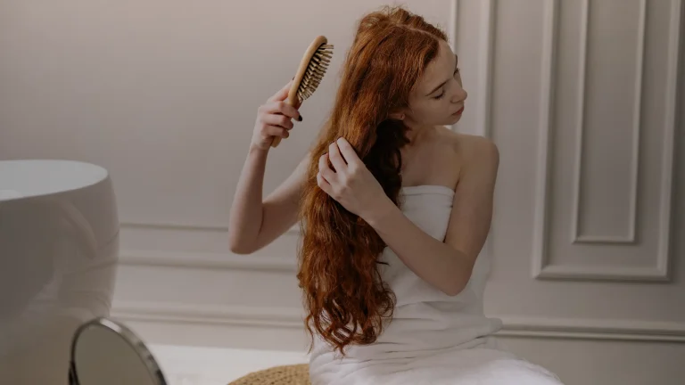 Femme aux longs cheveux auburn se brossant les cheveux