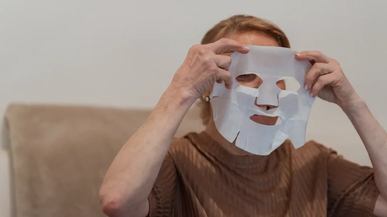 Femme appliquant un masque visage en tissu à deux mains